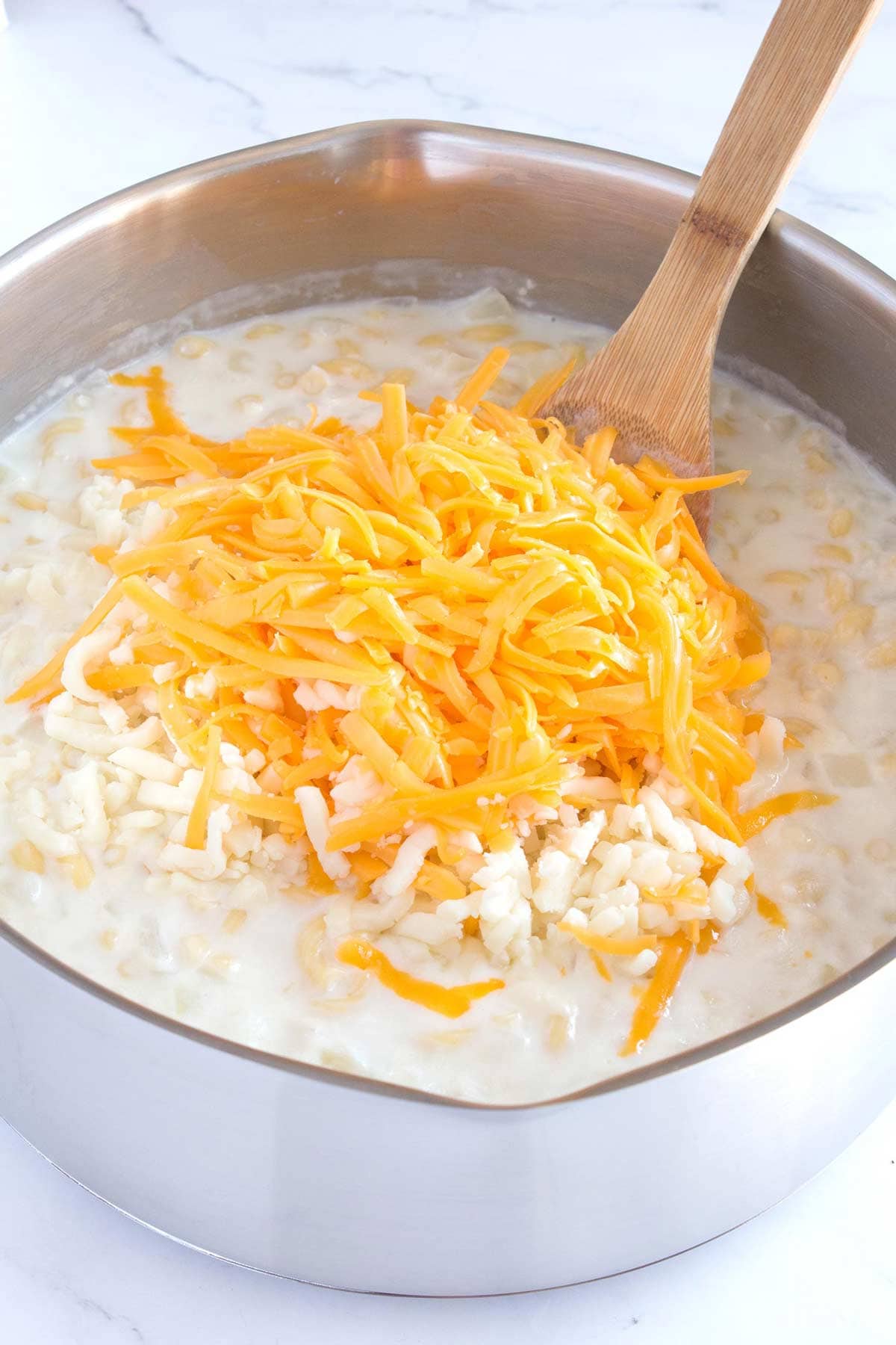 Stirring in a combination of cheeses for a perfectly cheesy sauce.