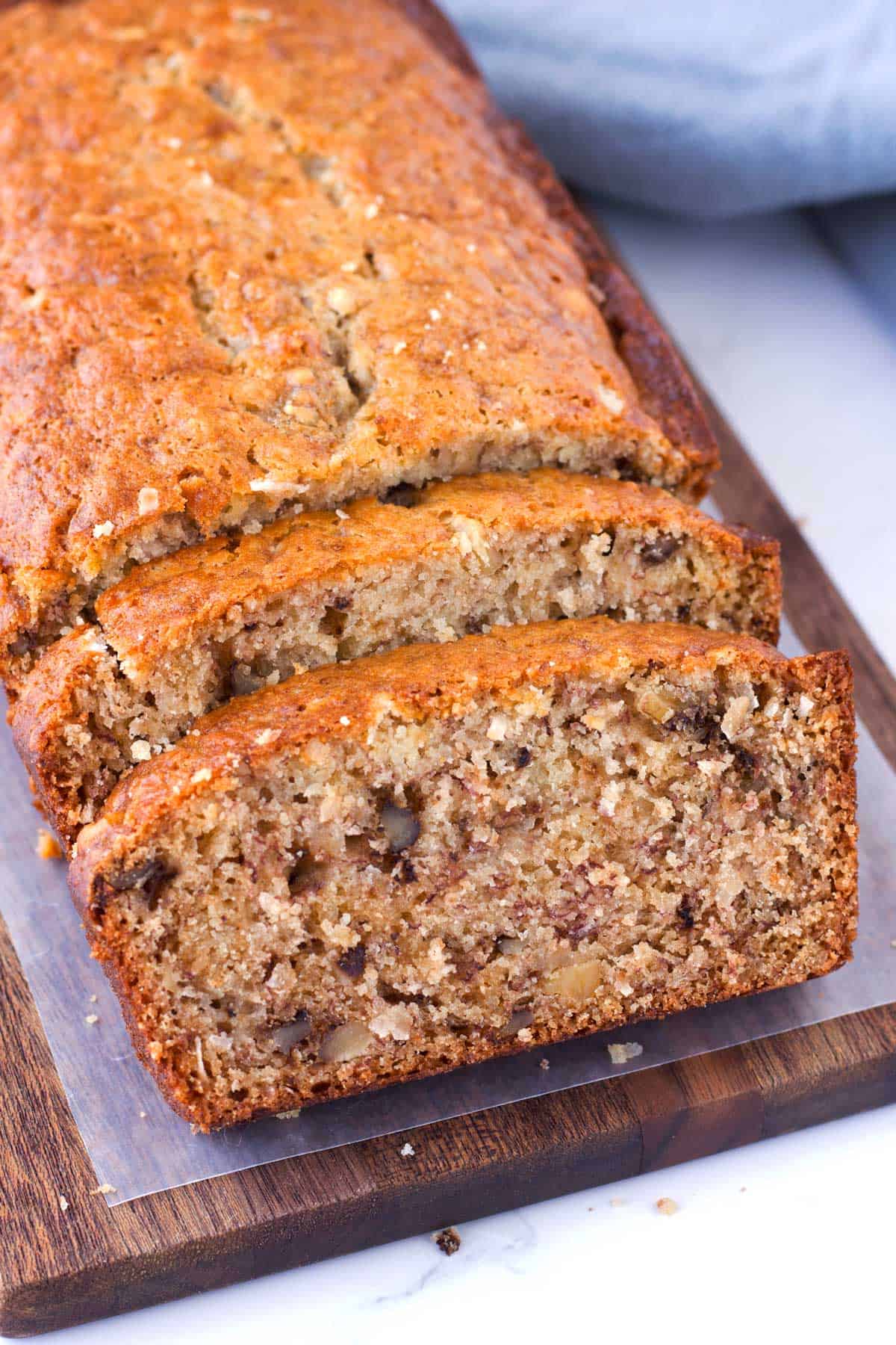 Golden brown crust on banana bread loaf with tender crumbs and walnuts.