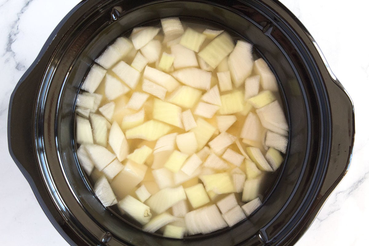 Potatoes, onions, and water in cooking pot.
