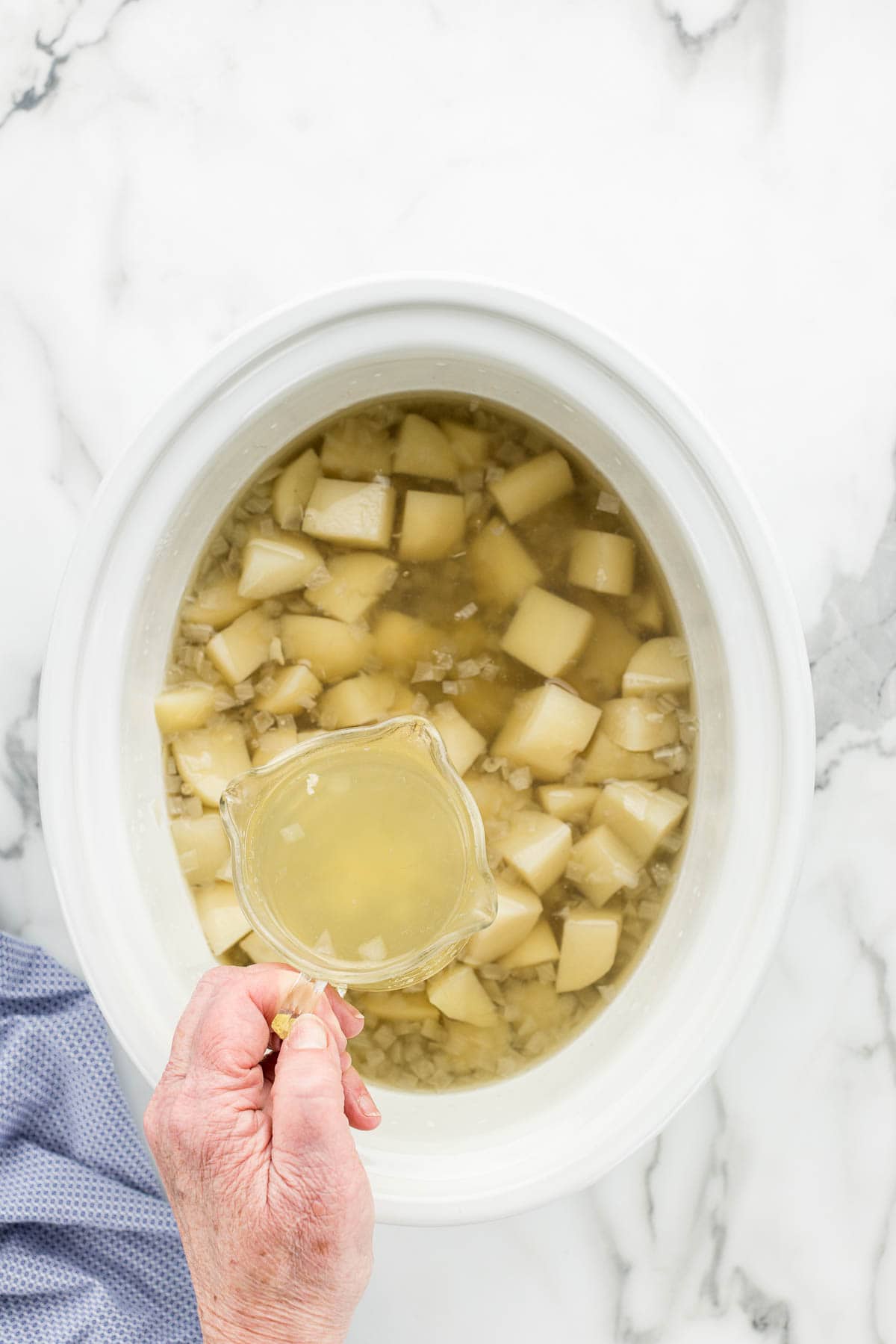 Soft potatoes in soup pot after cooking and removing excess water.
