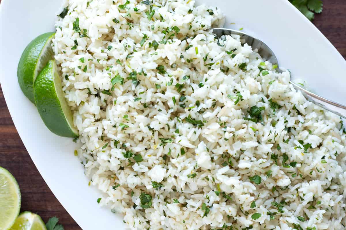 Cilantro lime rice on a platter with a serving spoon.