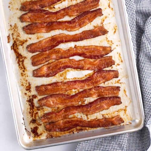 Strips of oven baked bacon on a sheet pan.