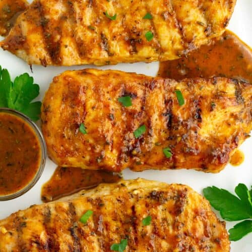 Overhead of chicken breasts on plate with honey mustard sauce drizzled on top.