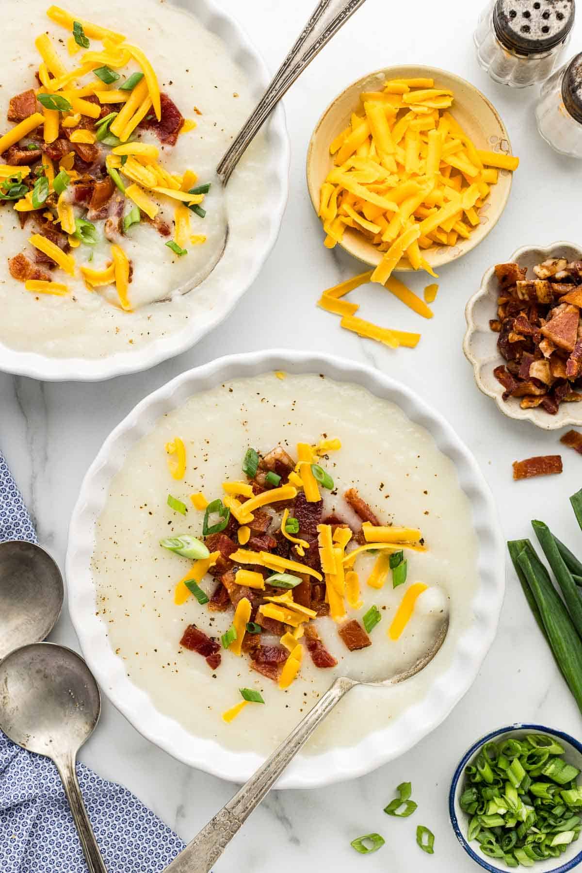 Up close picture of a bowl of Easy Potato Soup with blue napkin.