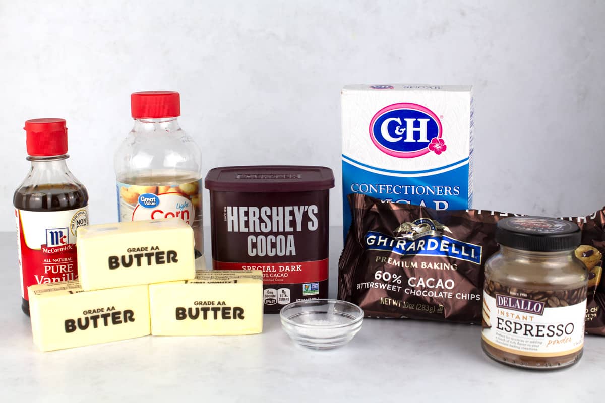 Ingredients for chocolate frosting on a white marble counter top.