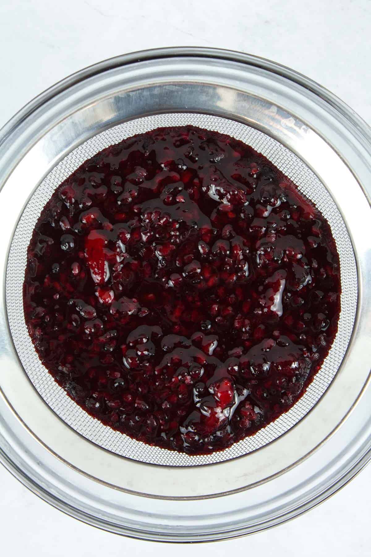 Straining berries for fruit filling to be used in cakes, pies, or tarts.