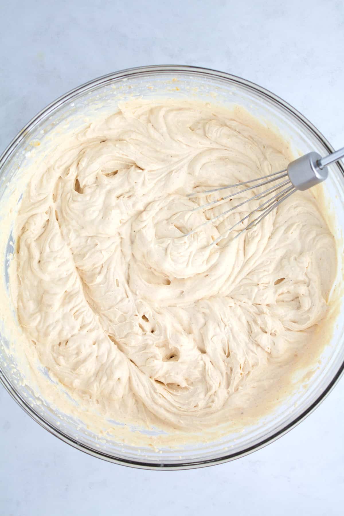 Peanut butter whipped cream in a glass bowl after whipping.