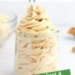 Peanut butter whipped cream piped into a glass jar with peanut butter chips in the foreground and text overlay on the top and bottom of the image.