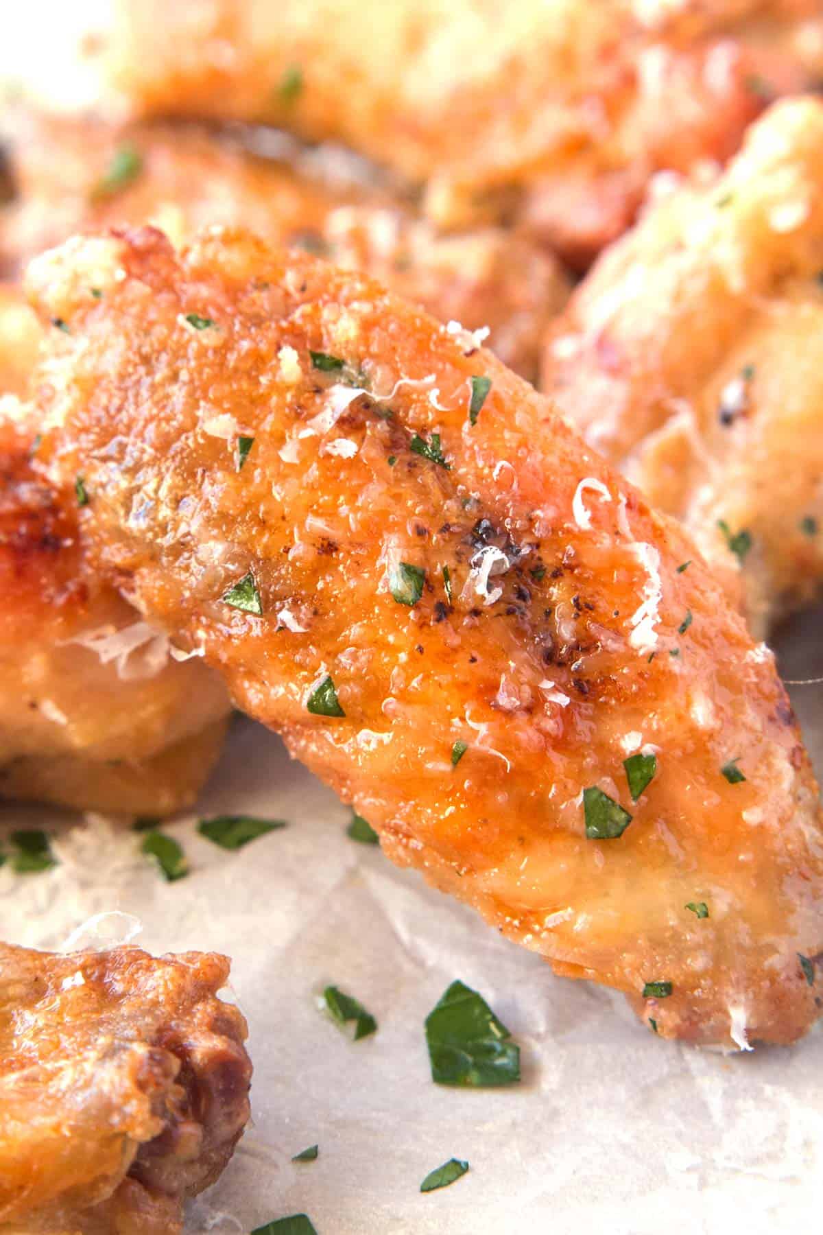 Parmesan and garlic chicken wings sprinkled with parsley.