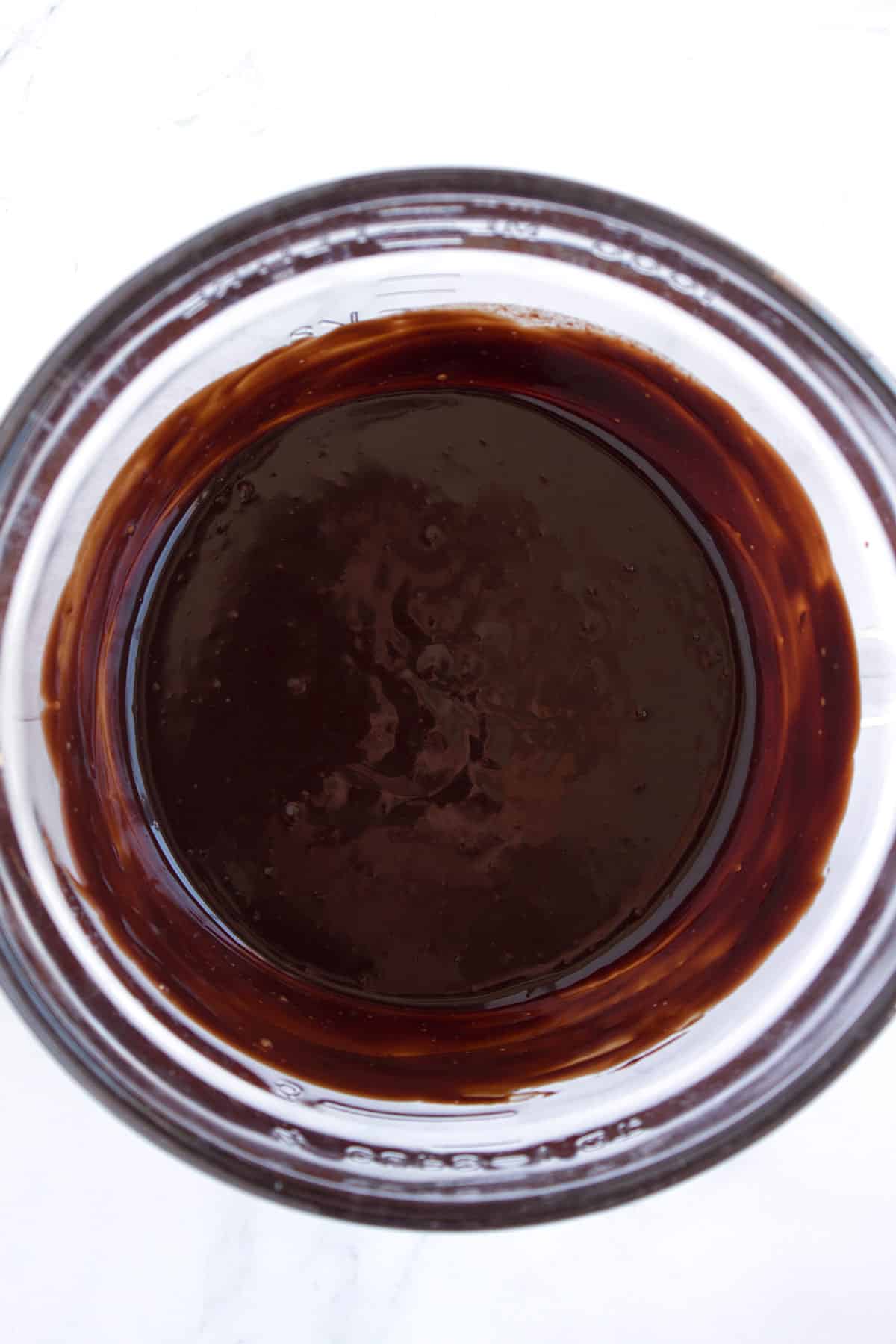 Dark chocolate ganache in a glass bowl.