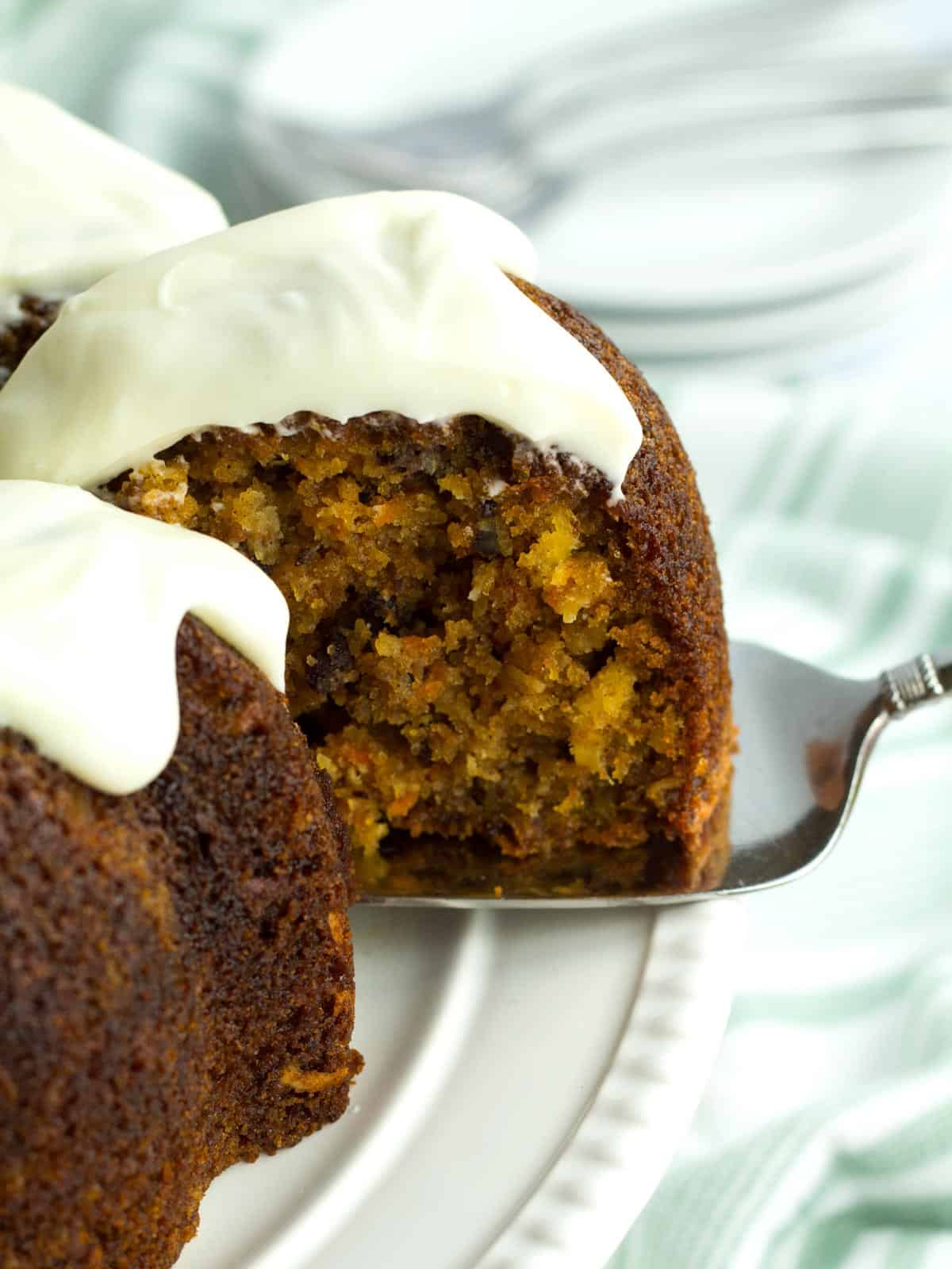 Light and fluffy cream cheese frosting on piece of carrot bundt cake with pineapple.
