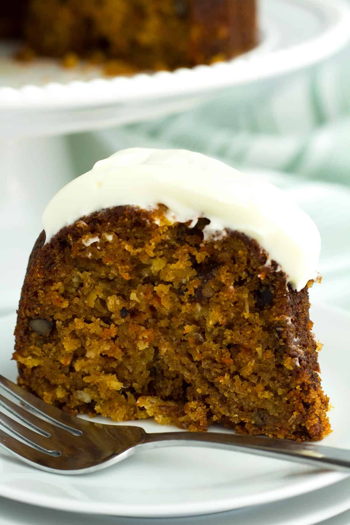 Carrot bundt cake piece studded with pineapple, coconut, and pecans.