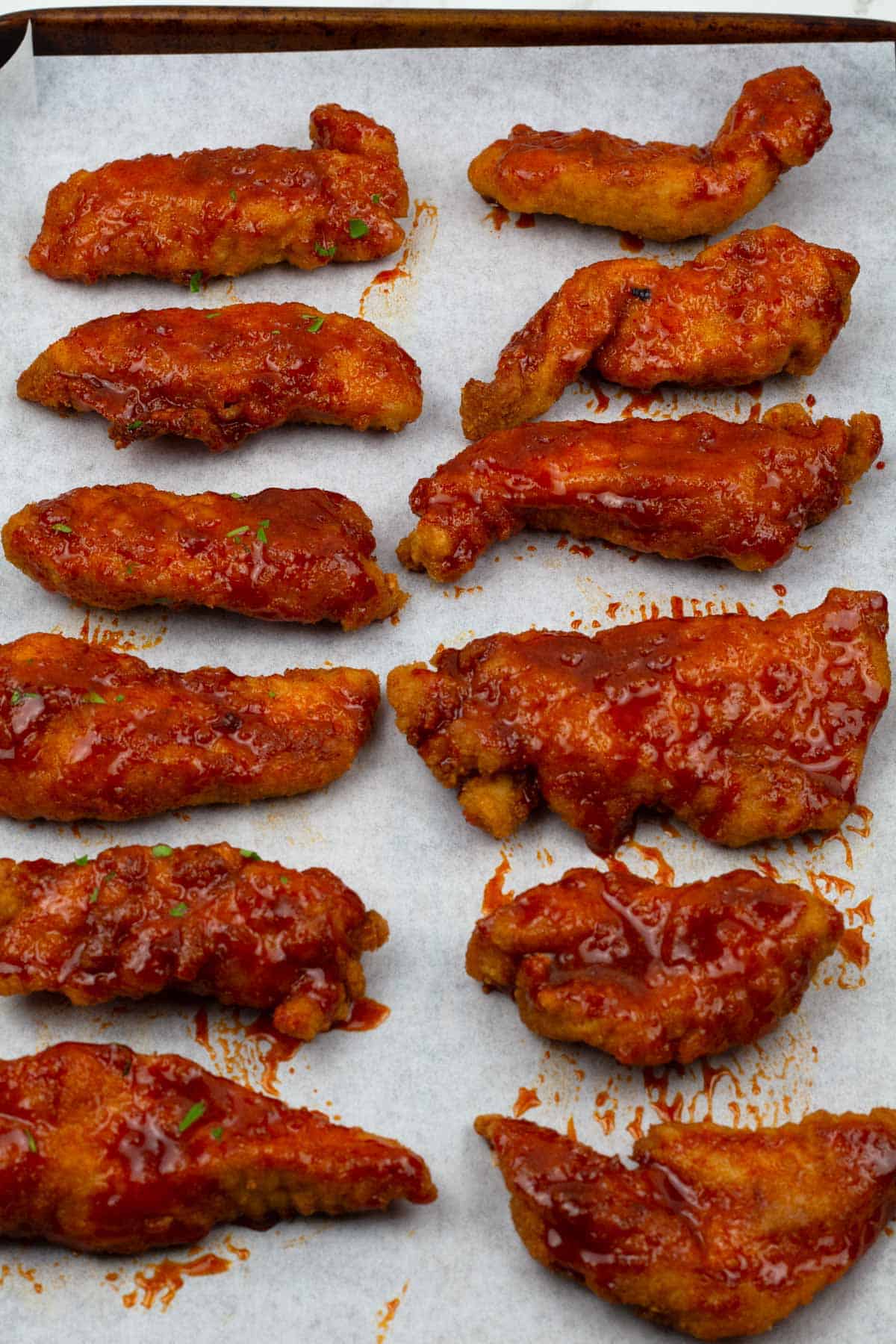 Chicken tenders for wrap baked and glazed with red heat-infused honey sauce.