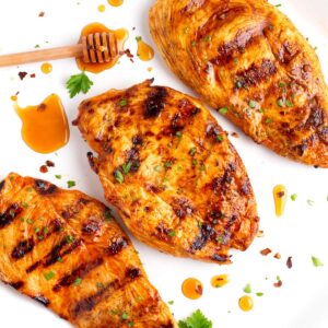Platter of hot honey marinated chicken breasts with parsley and honey.