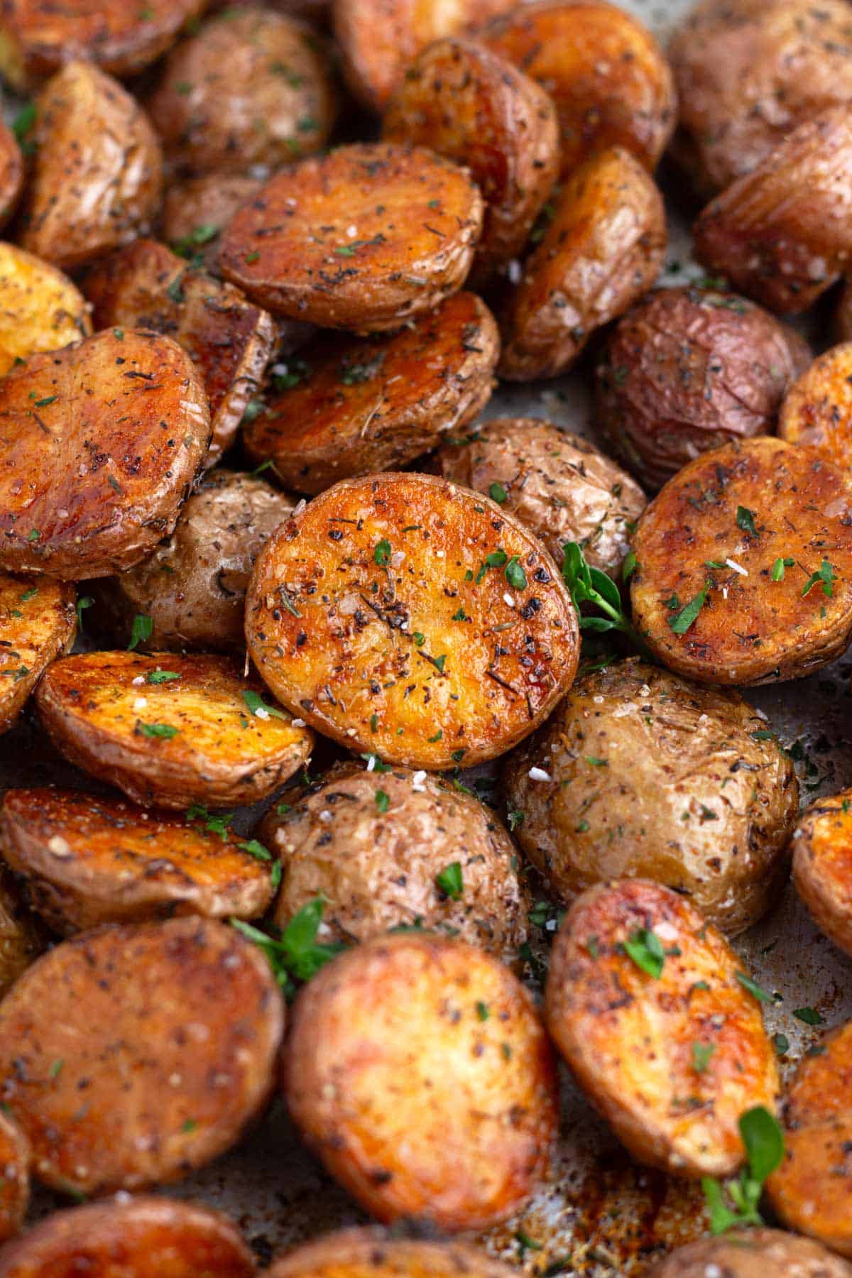 Salt flakes on crispy, golden brown roasted potatoes on a sheet pan fresh from the oven.