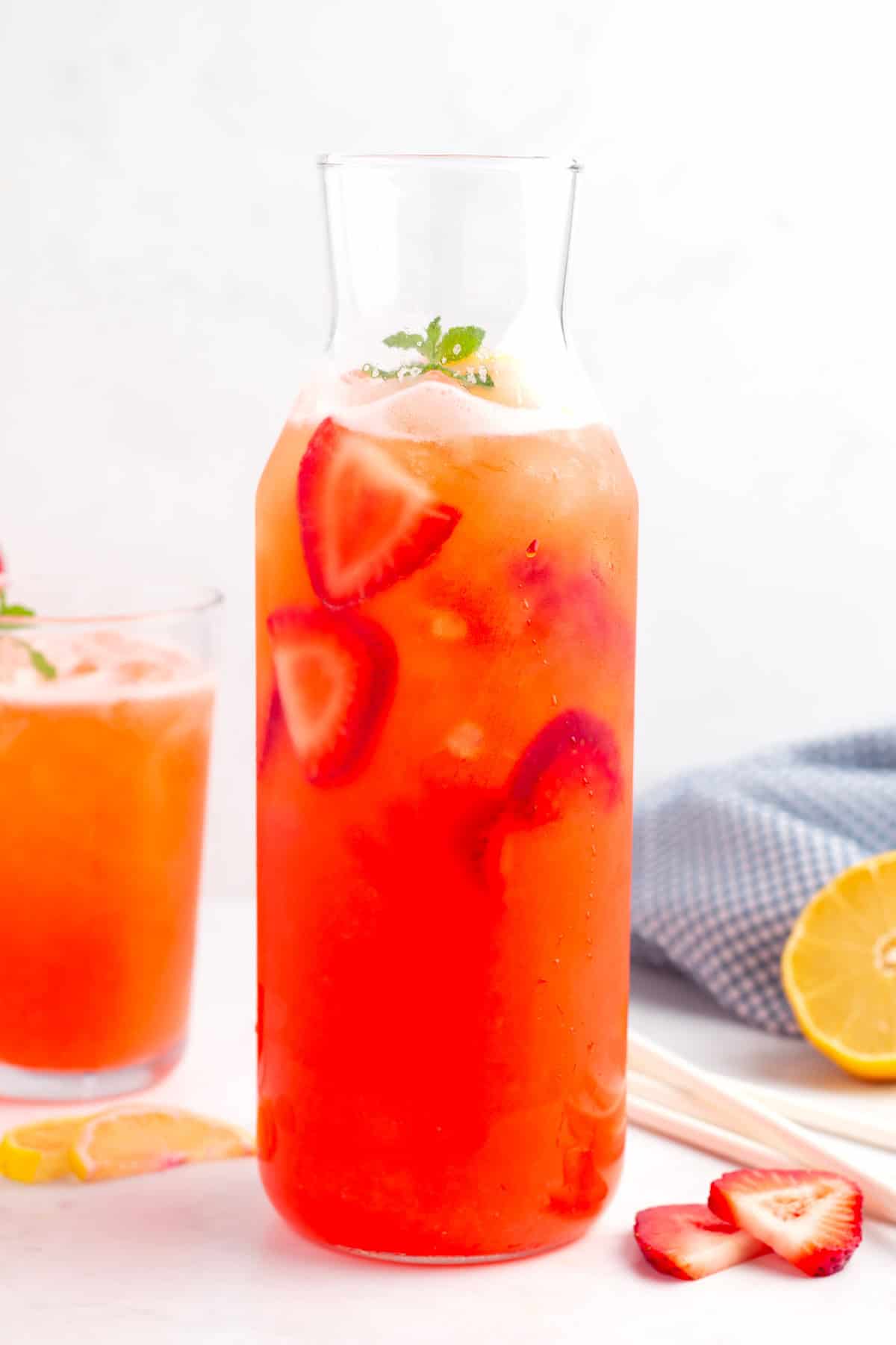 Pitcher filled with ice and pink lemonade made with fresh, ripe strawberries.