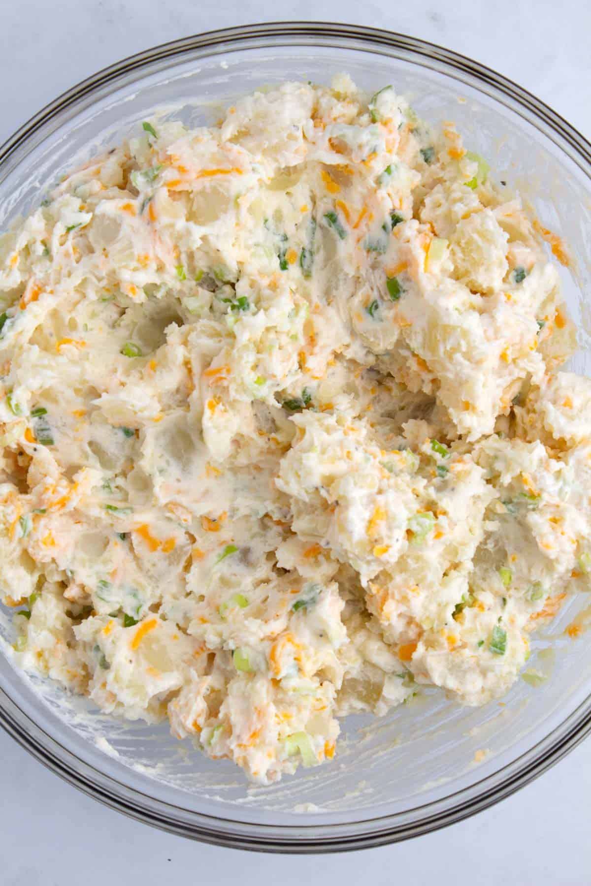 Sour cream potato bake mixture stirred together in a bowl.