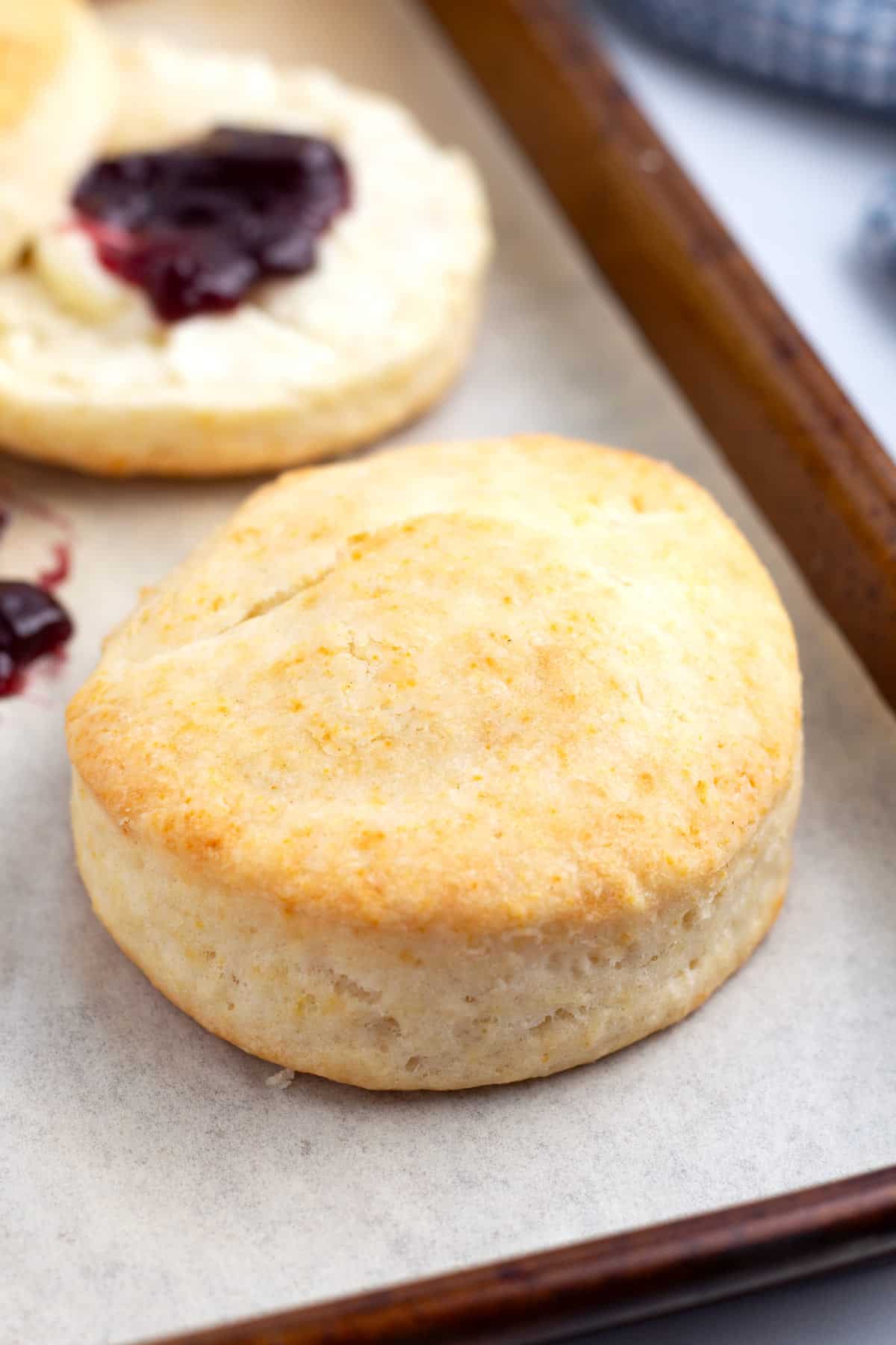 Final baked biscuit on cookie sheet with parchment paper.