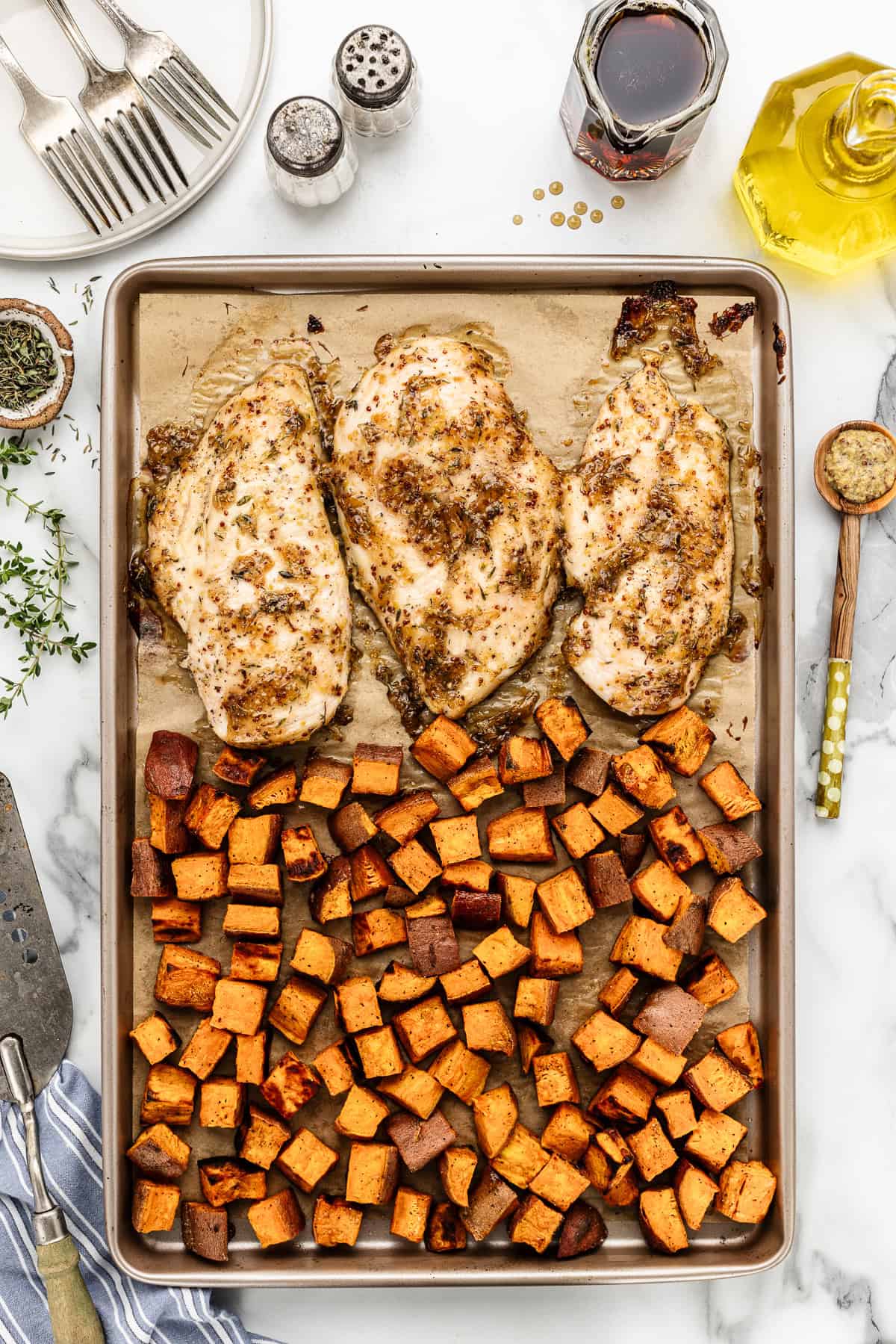 Chicken breast sheet pan dinner with sweet potatoes after baking in the oven.