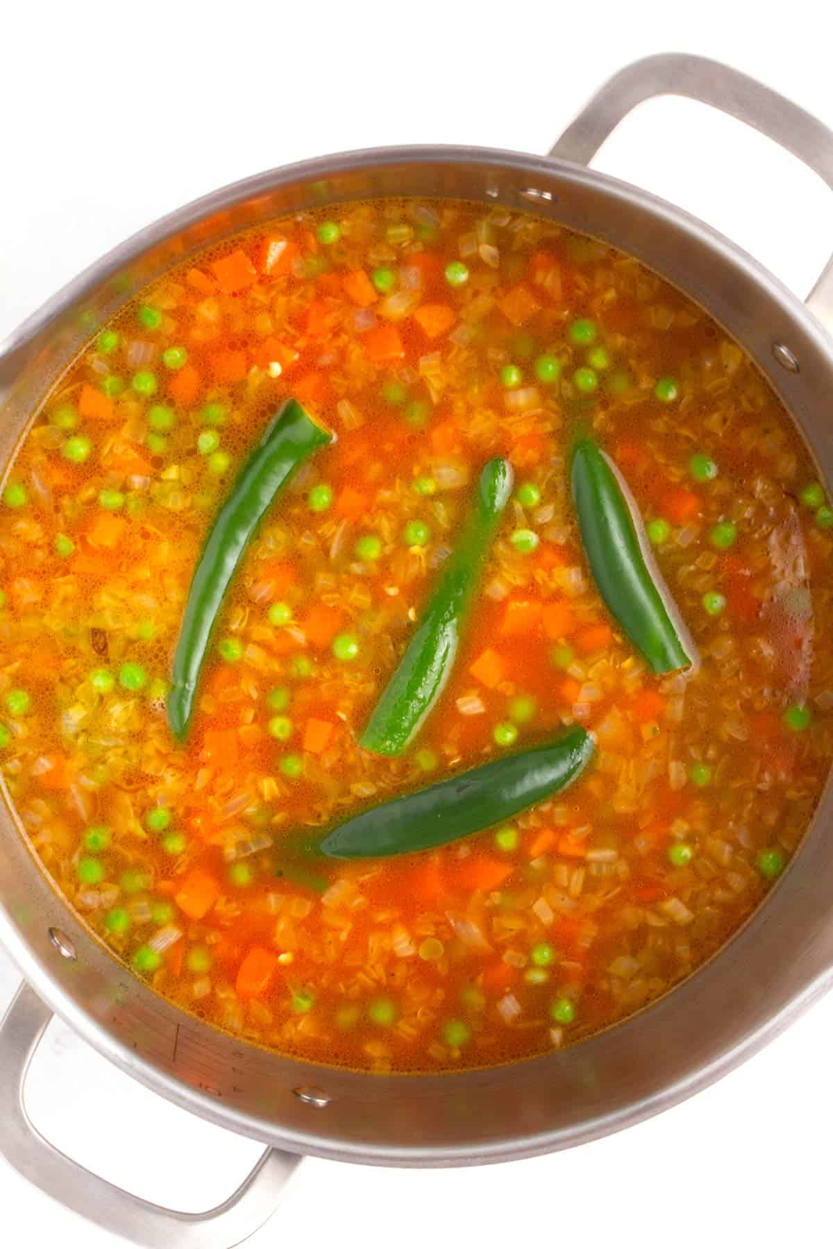 Showing how to make Mexican rice with serrano peppers, peas, and carrots.