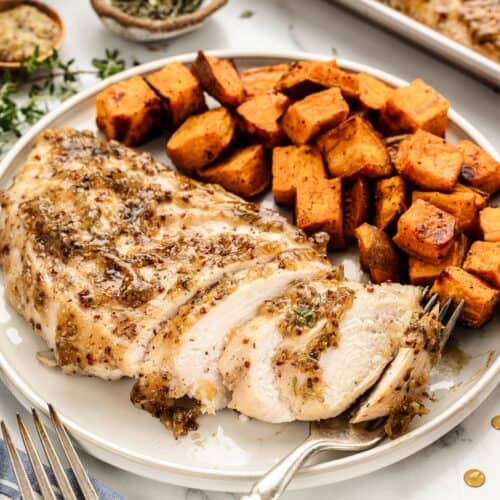 Dinner plate of maple chicken breasts with a side of sweet potatoes.