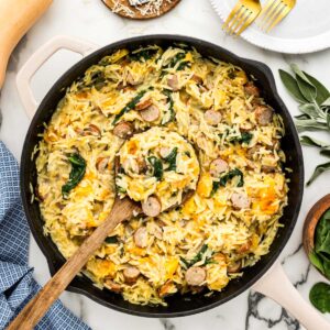 One skillet of orzo pasta recipe filled with chicken sausage, butternut squash, spinach, cream and parmesan cheese.