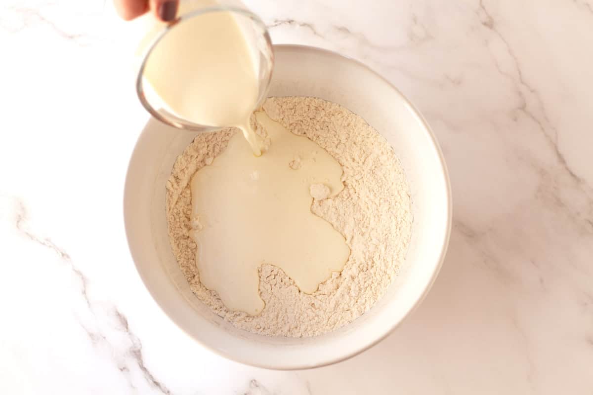Pouring cream into the bowl of dry ingredients.