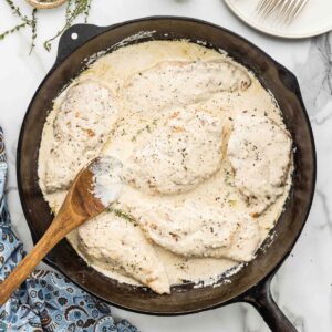 Easy weeknight dinner of creamy garlic chicken in a skillet.