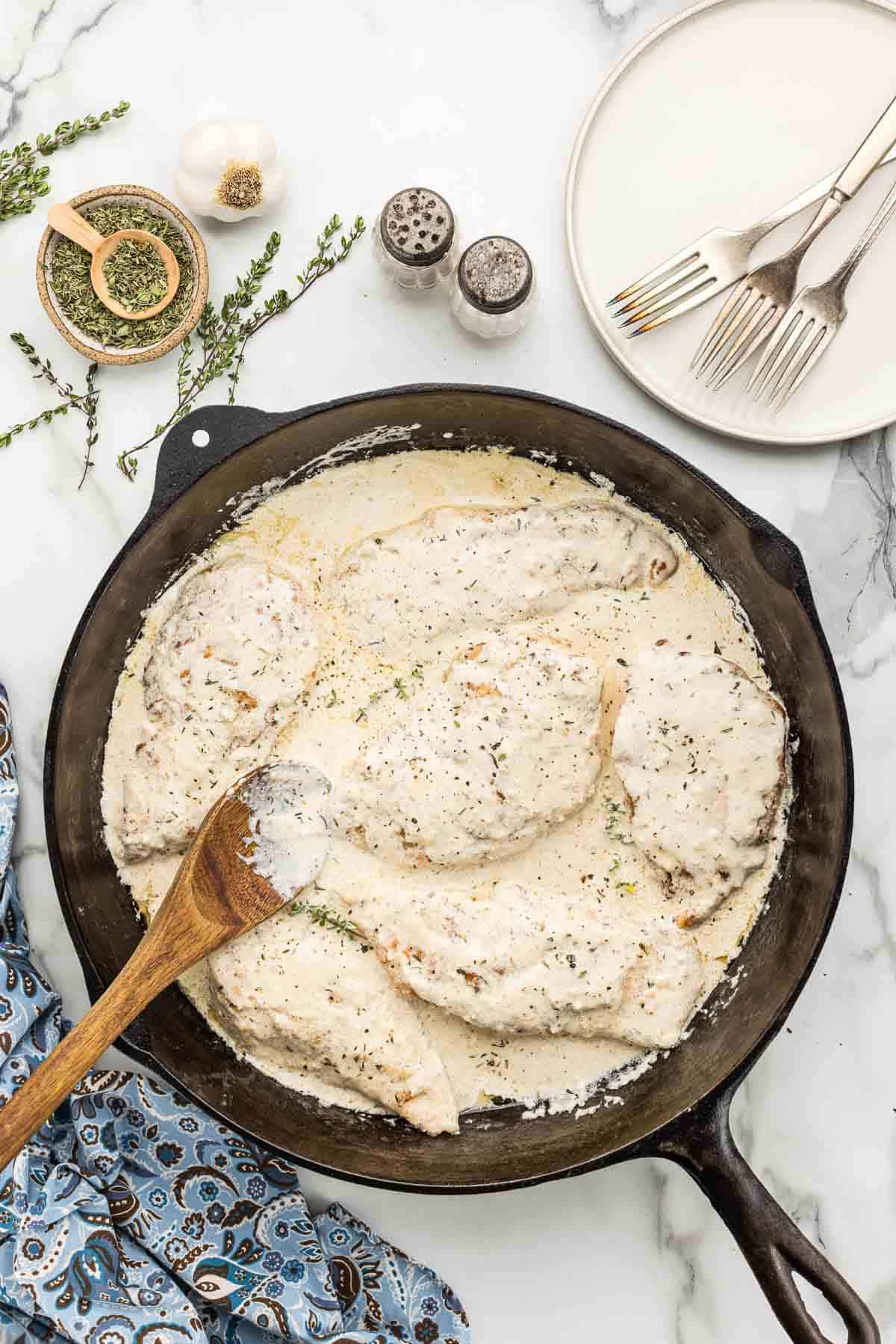 Chicken breasts after being simmered in heavy cream and chicken broth pan.