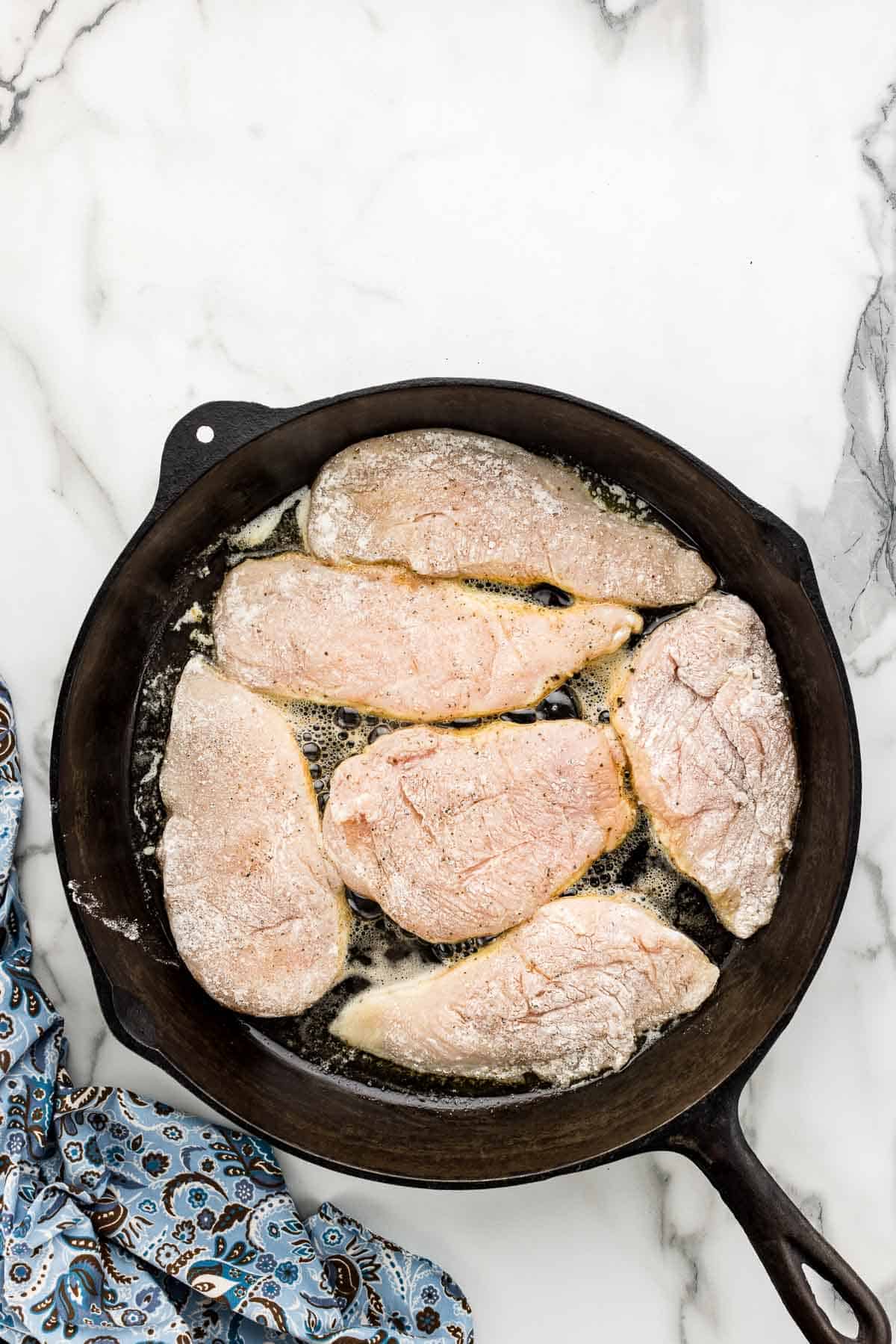 Browning chicken on first side in large skillet.