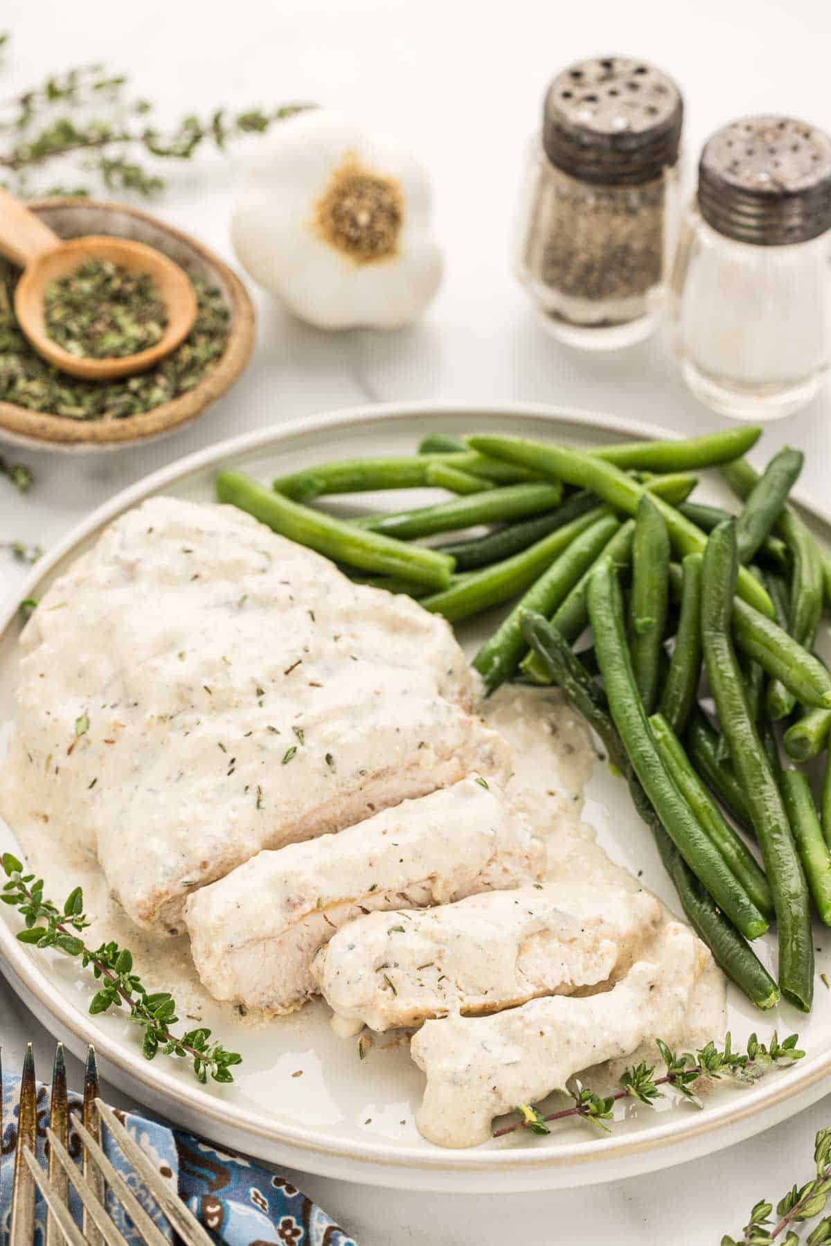 Dinner plate filled with green beans and garlic chicken in creamy sauce.