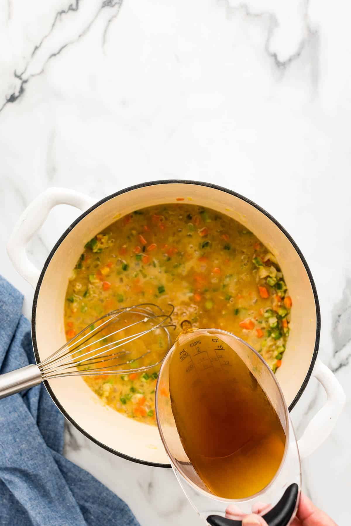 Whisking broth into roux while making the ham filled potato soup.