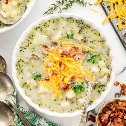 Cozy bowl of cheesy potato and broccoli soup topped with cheddar and bacon crumbles.