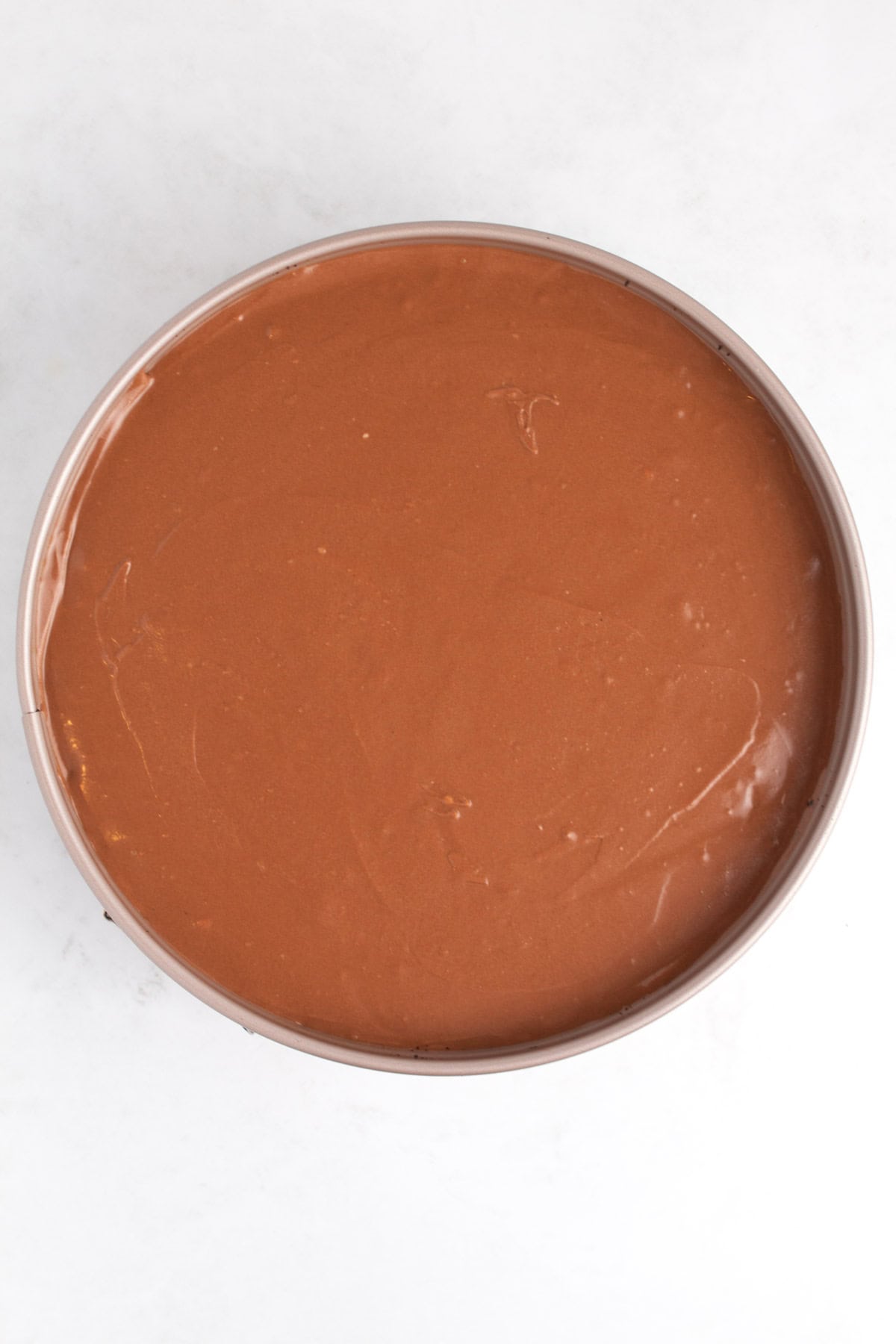 Springform pan filled with uncooked chocolate batter.