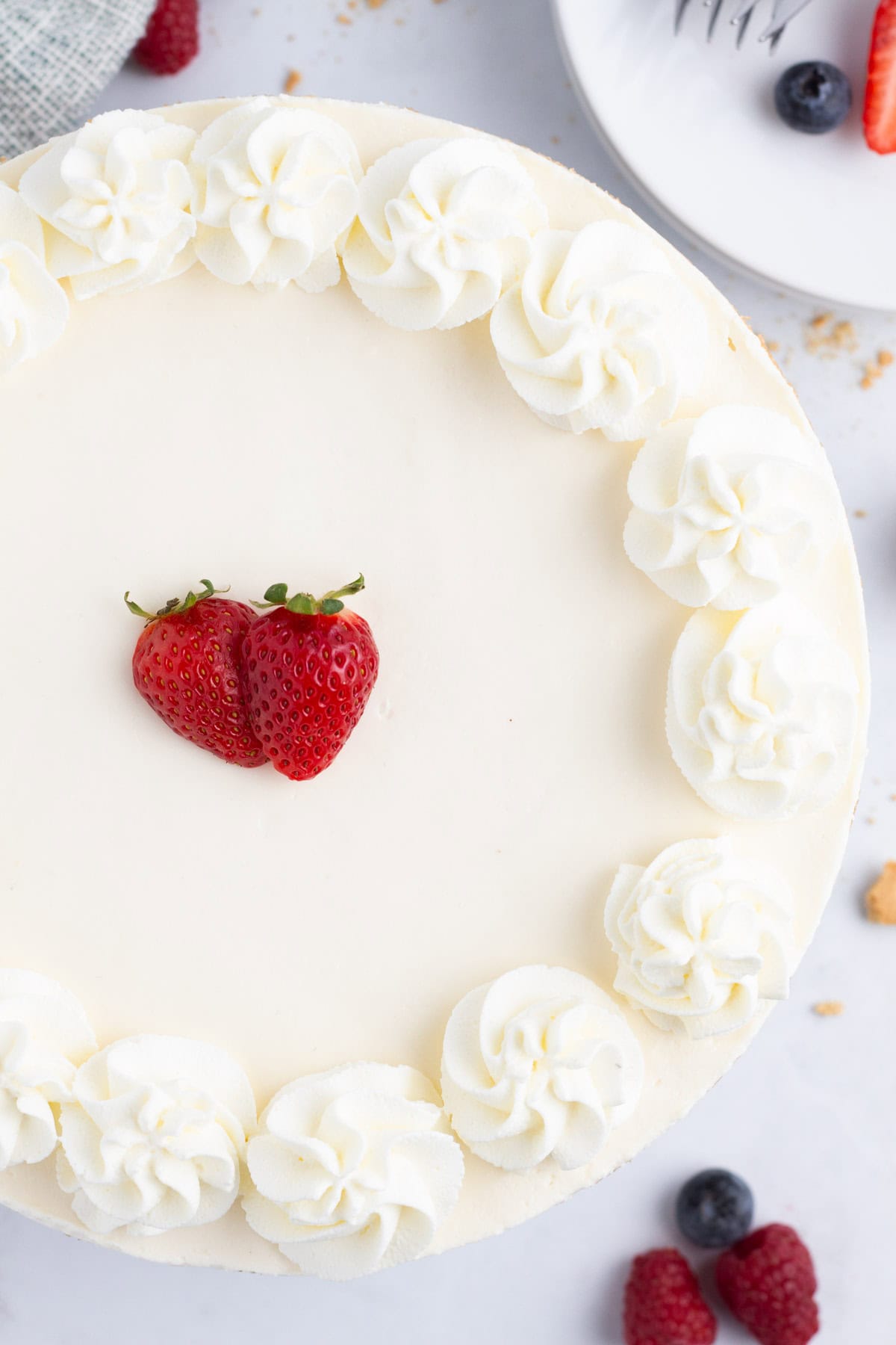 Entire light and fluffy no oven cheesecake decorated with fresh berries.
