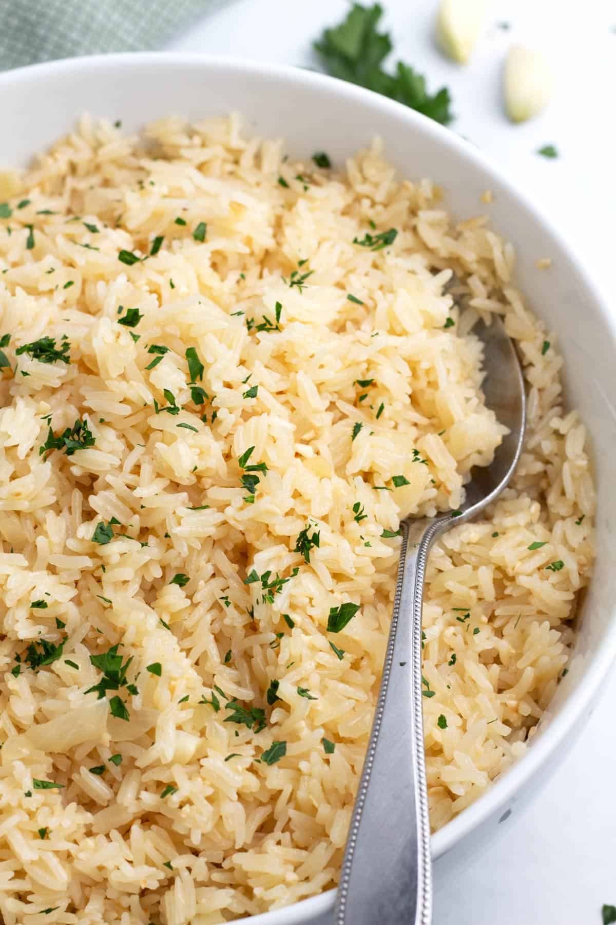 A serving of garlic rice with a spoon resting on the rim.