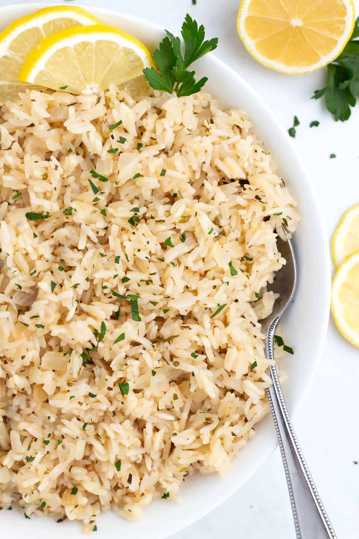 Delicious lemon rice in a bowl with a spoon leaning against the rim.