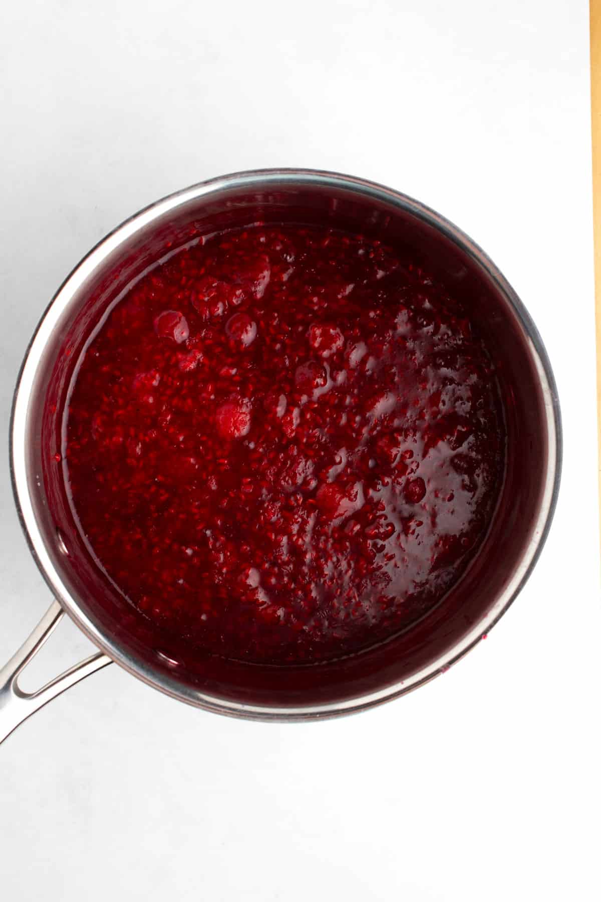 Raspberry sauce in a steel saucepan.