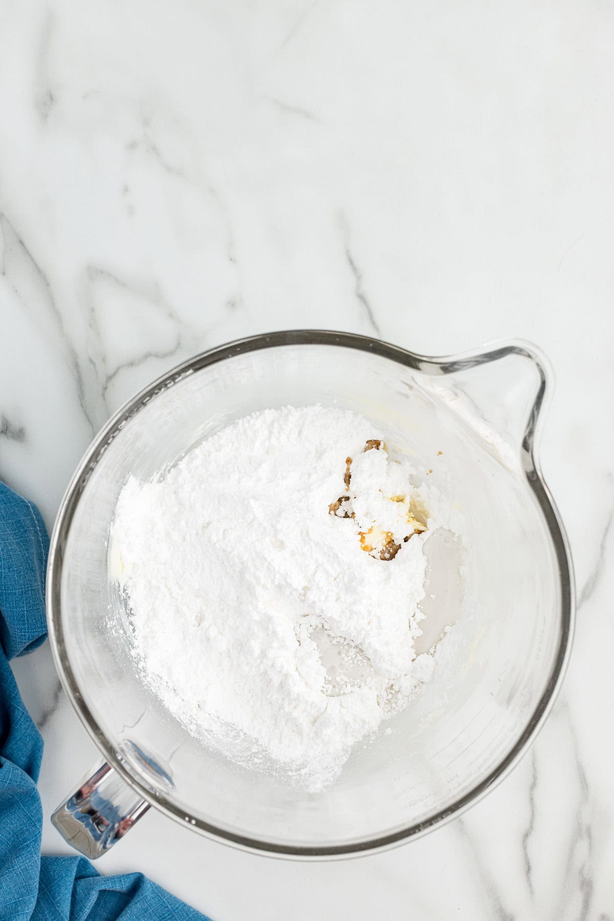A measuring pitcher with frosting ingredients in it.
