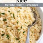Rice with garlic in a serving dish with a spoon and gray text overlaid at the top.