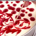 Batter in a round baking pan with drops of fruit topping getting swirled in by a toothpick with a graphic overlay.