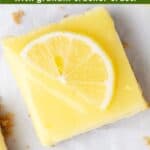 A cheesecake lemon bar with fresh topping and green overlaid text.
