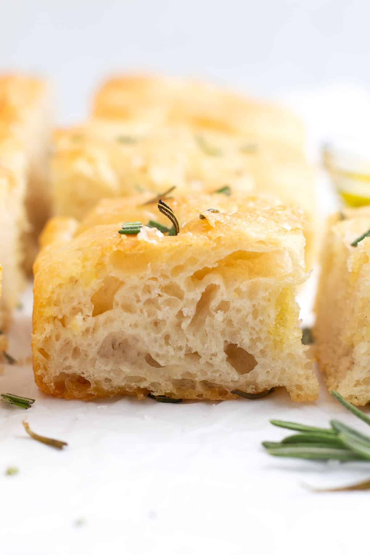 A slice of fluffy focaccia bread on parchment paper.