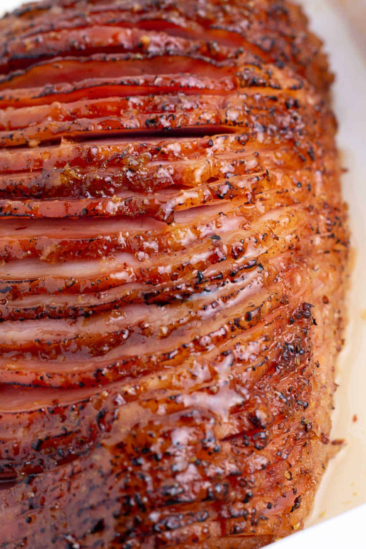 A sliced ham with glaze dripping down the sides.
