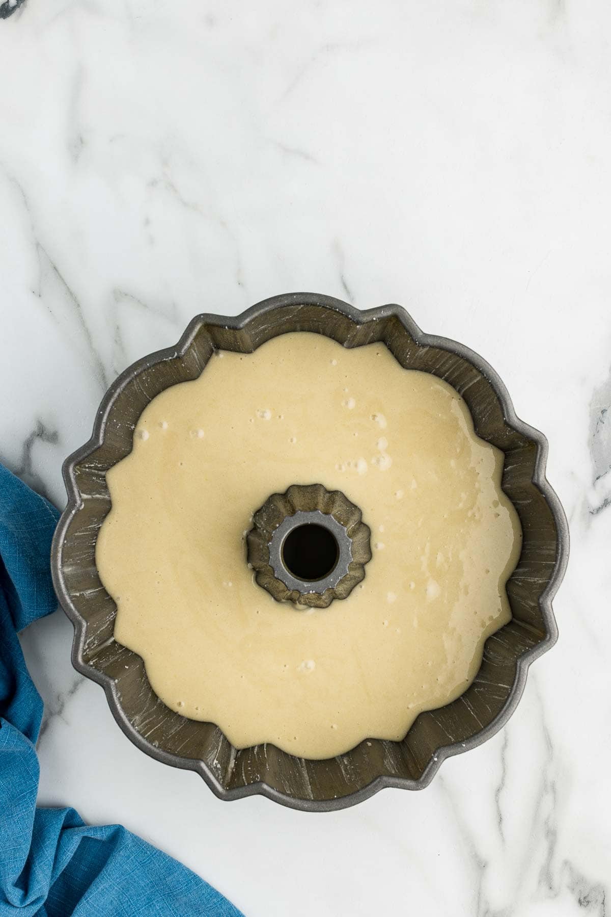 Cake batter in a Bundt cake baking pan.