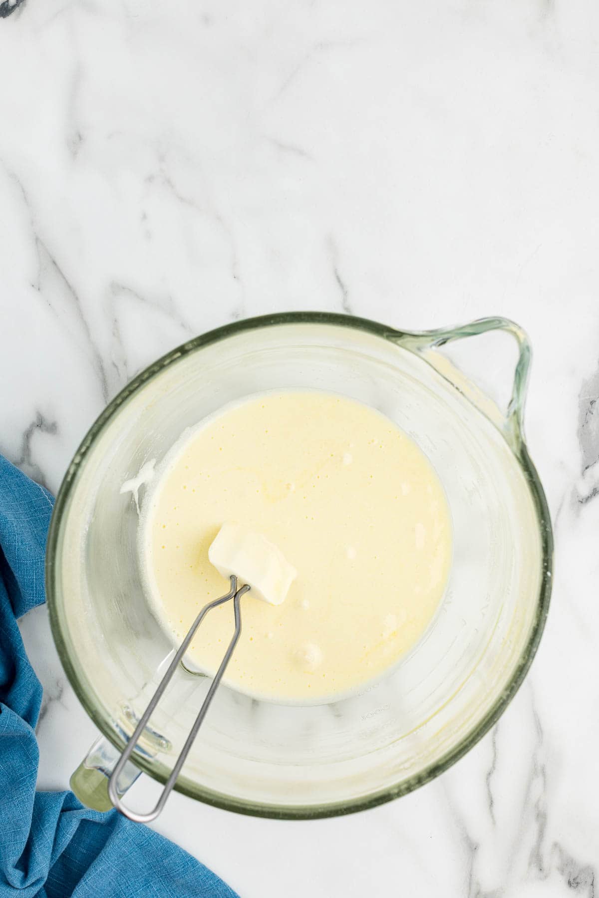 Cake batter in a measuring glass with a small spatula in it.