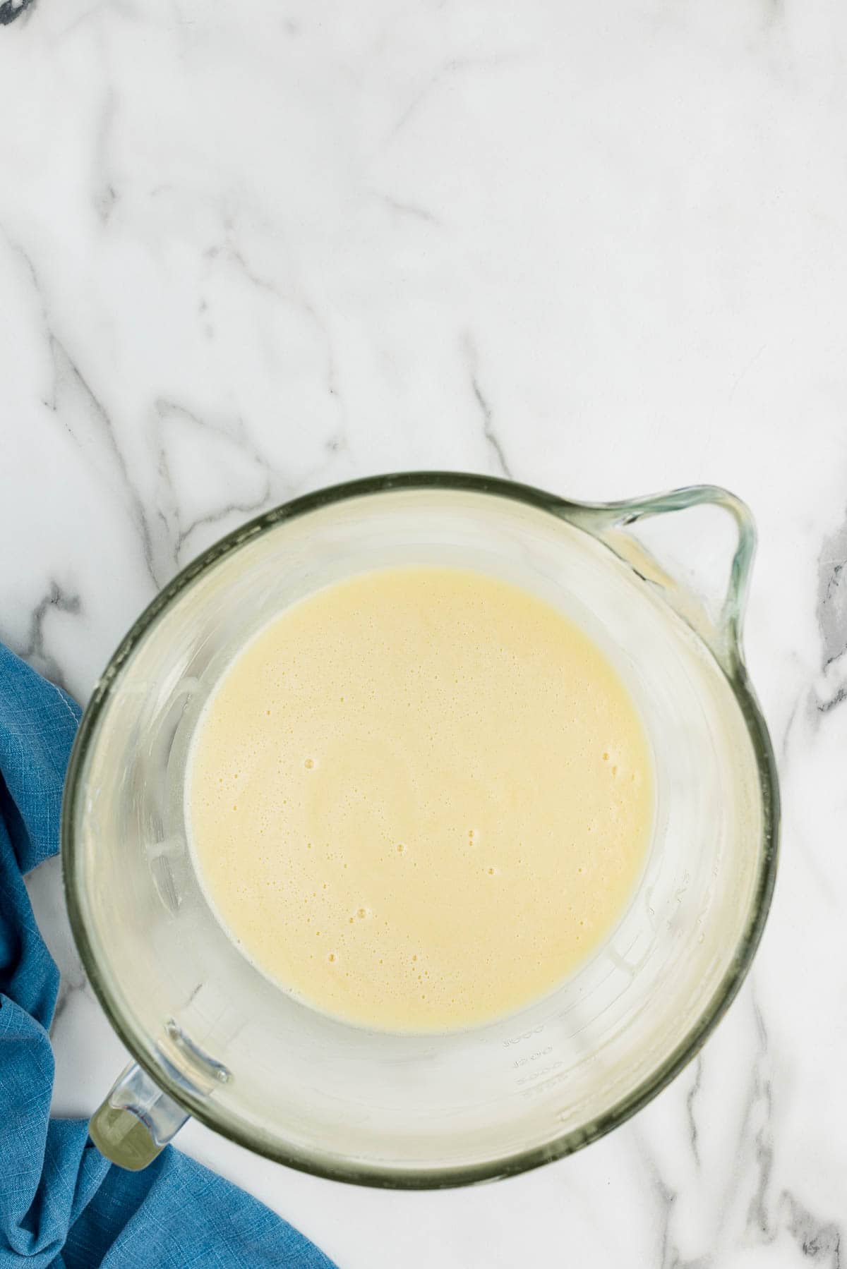 Mixed cake batter in a glass measuring cup.