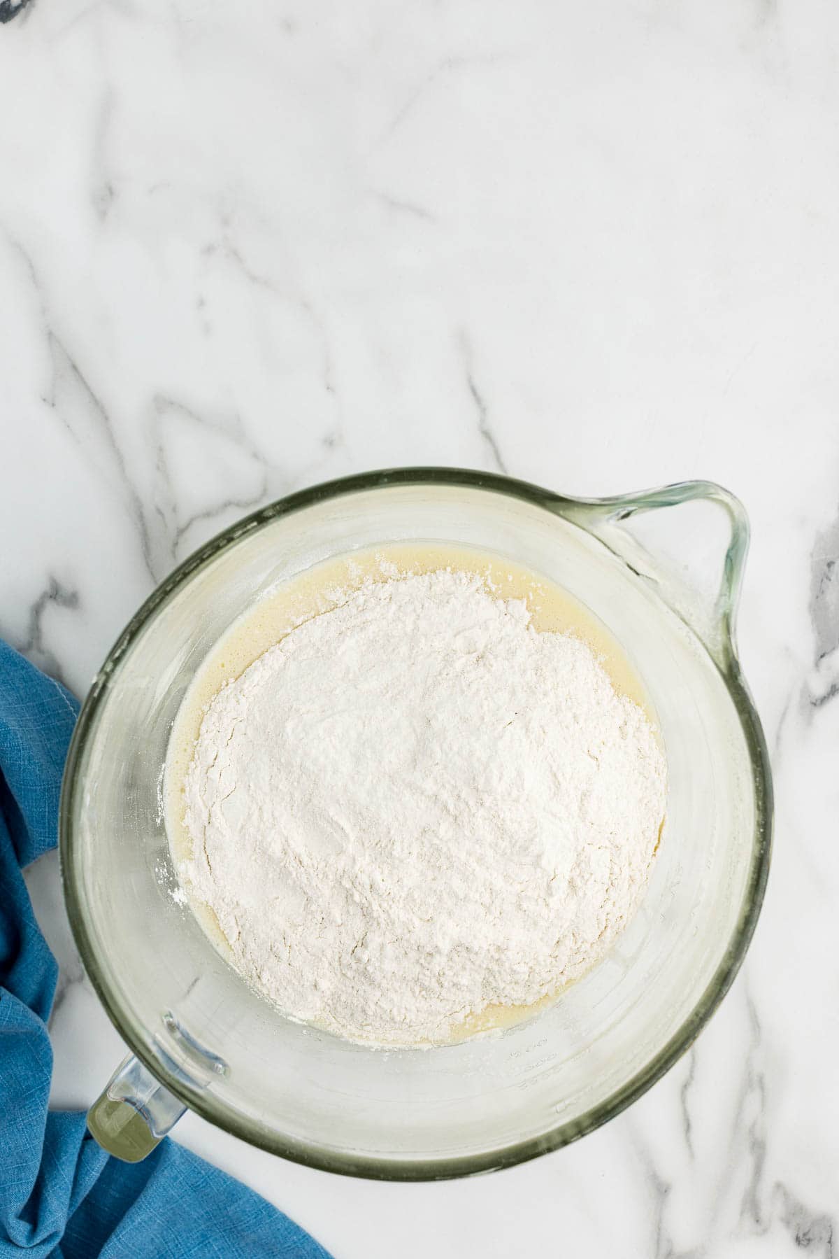 A large measuring cup of cake batter with flour added.