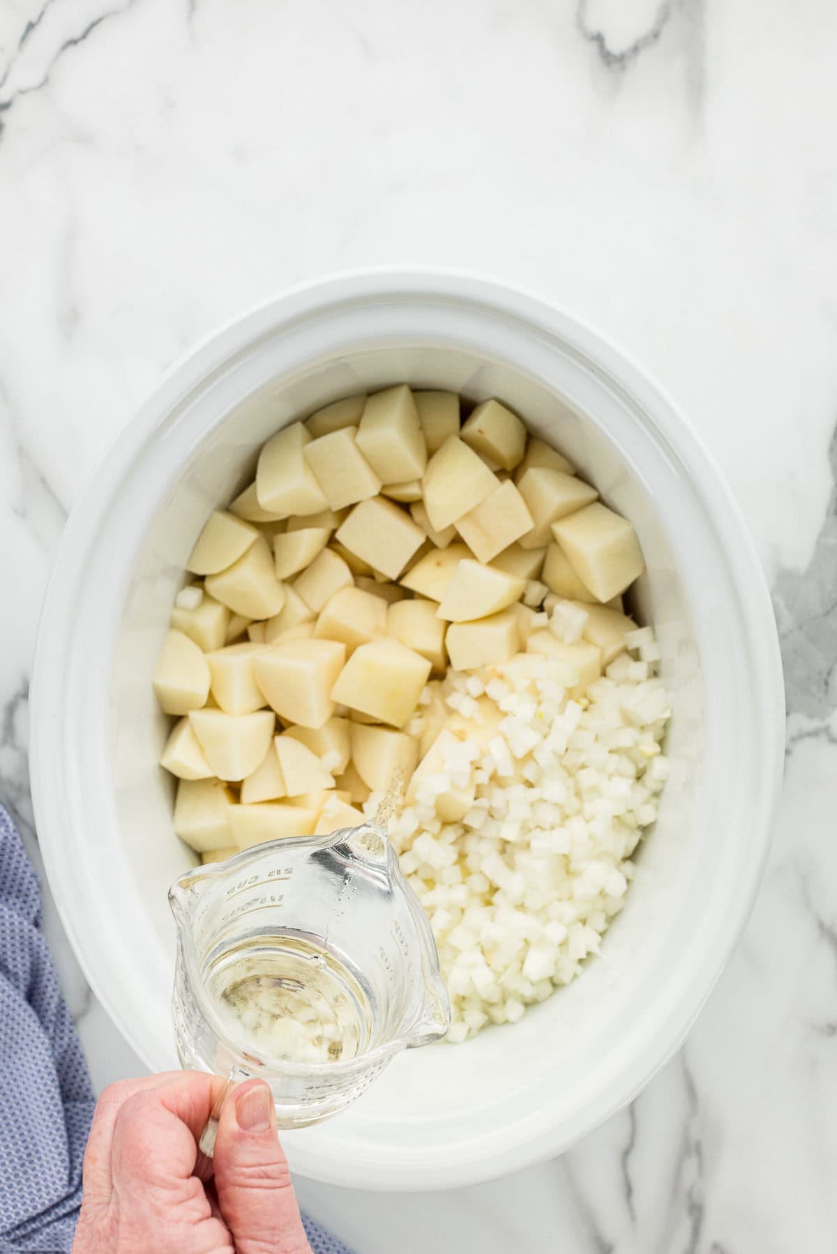 Adding water to the diced potato and onions.
