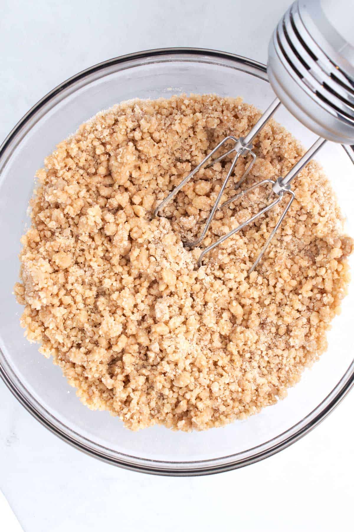 Mixed dough in a large bowl with a hand blender in the top corner.